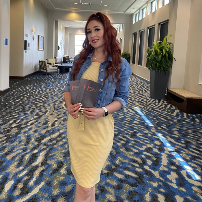 Patty Solis holding brochures of Linda's salon